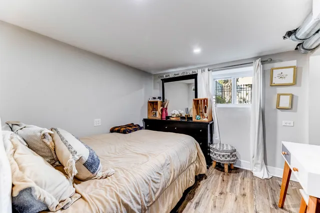 a bedroom with a bed and wooden floor