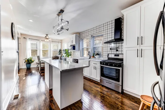 a kitchen with stainless steel appliances a sink stove and refrigerator