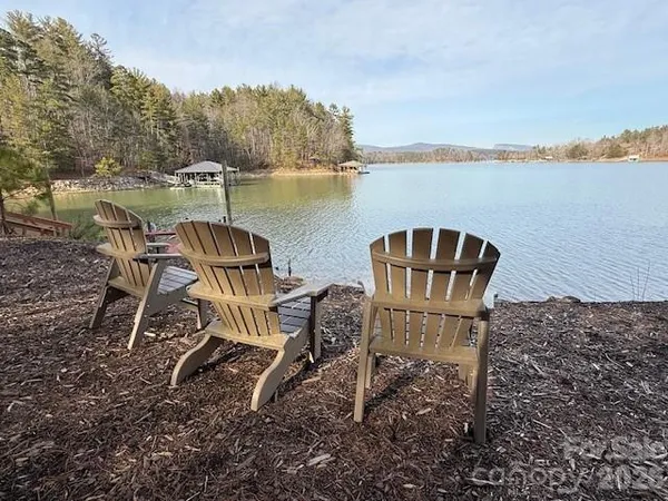 a view of a lake with table and chairs