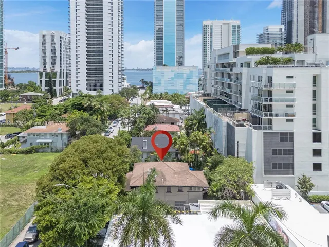 a aerial view of multi story residential apartment building with yard and large trees