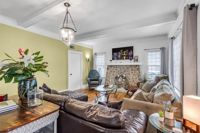 a living room with furniture chandelier and a flat screen tv