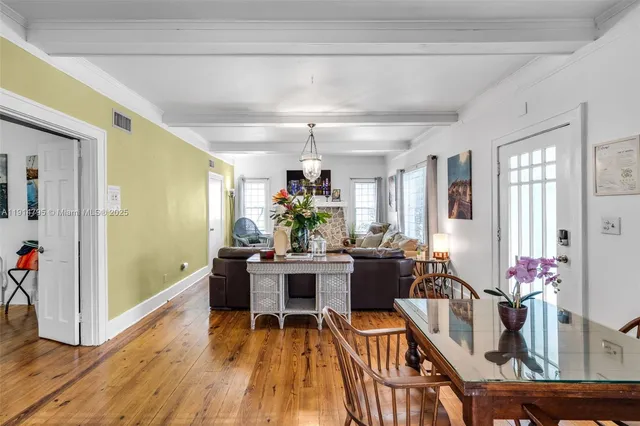 a kitchen with a table chairs and white cabinets