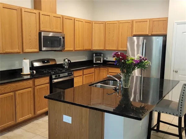 a kitchen with stainless steel appliances granite countertop a refrigerator sink and cabinets