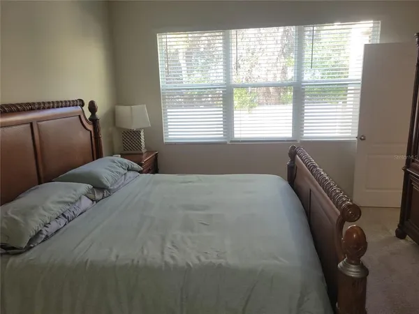 a bed sitting in a bedroom next to a window
