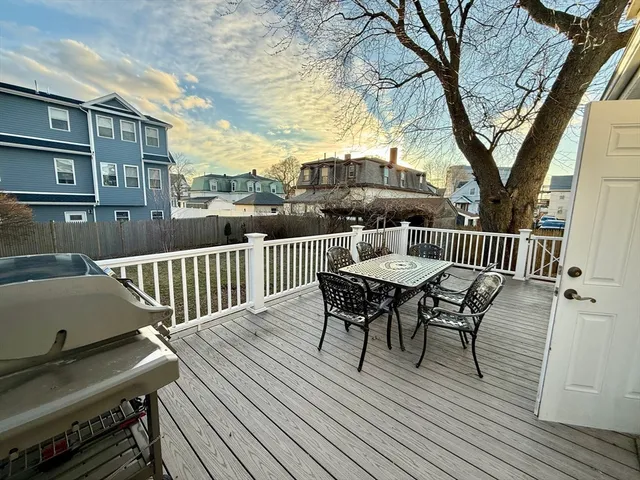 a view of a roof deck with table and chairs and wooden floor