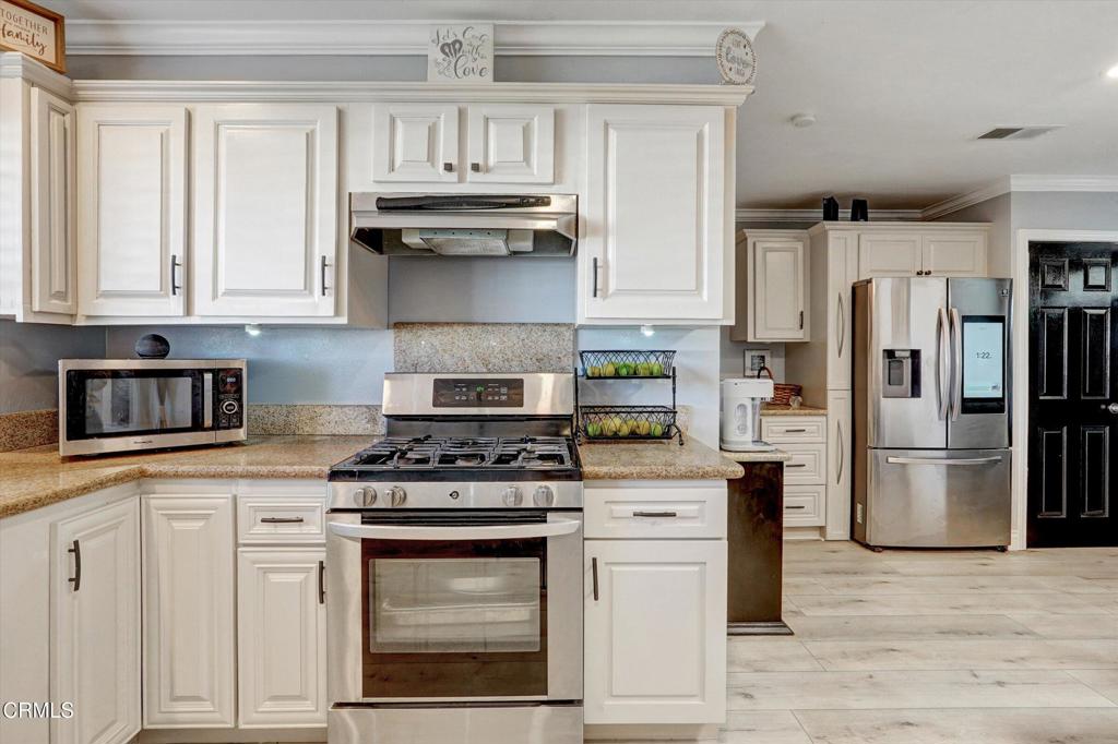 1960 Peoria Place Oxnard, CA 93033 - Photo 29 of 36 a kitchen with stainless steel appliances granite countertop a stove a refrigerator and a white cabinets