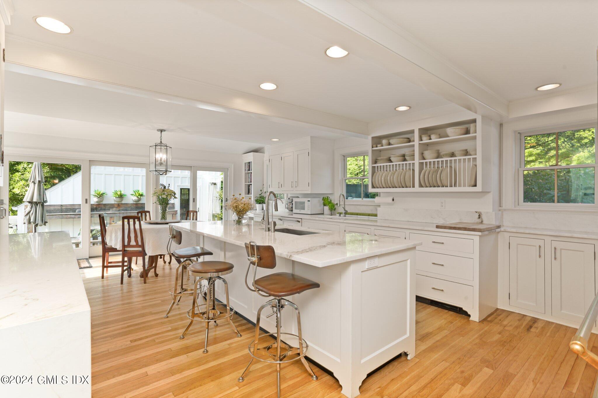 127 Dingletown Road Greenwich, CT 06830 - Photo 13 of 54 a kitchen with white cabinets and chandelier