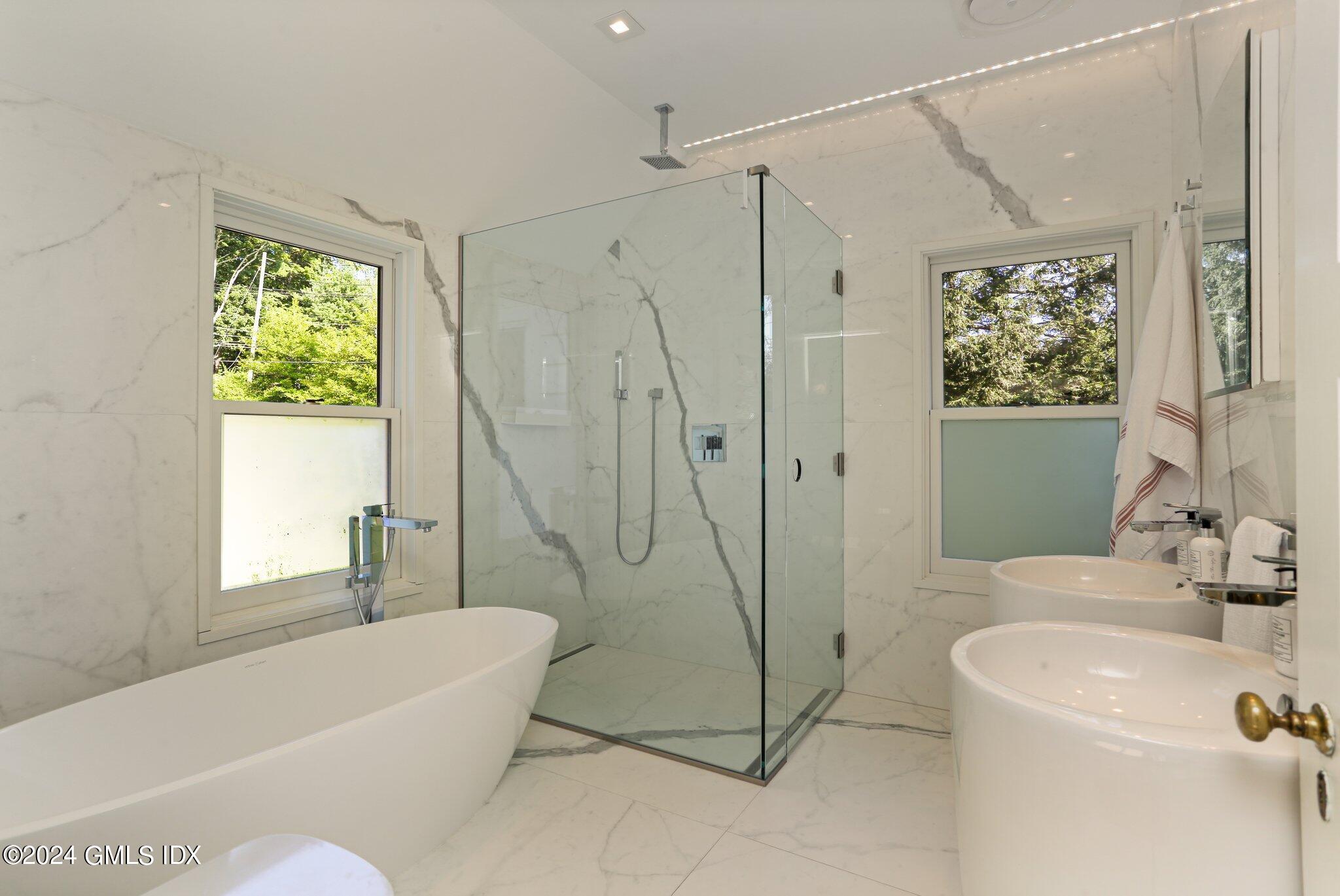 127 Dingletown Road Greenwich, CT 06830 - Photo 25 of 54 a bathroom with a bathtub a window and a shower