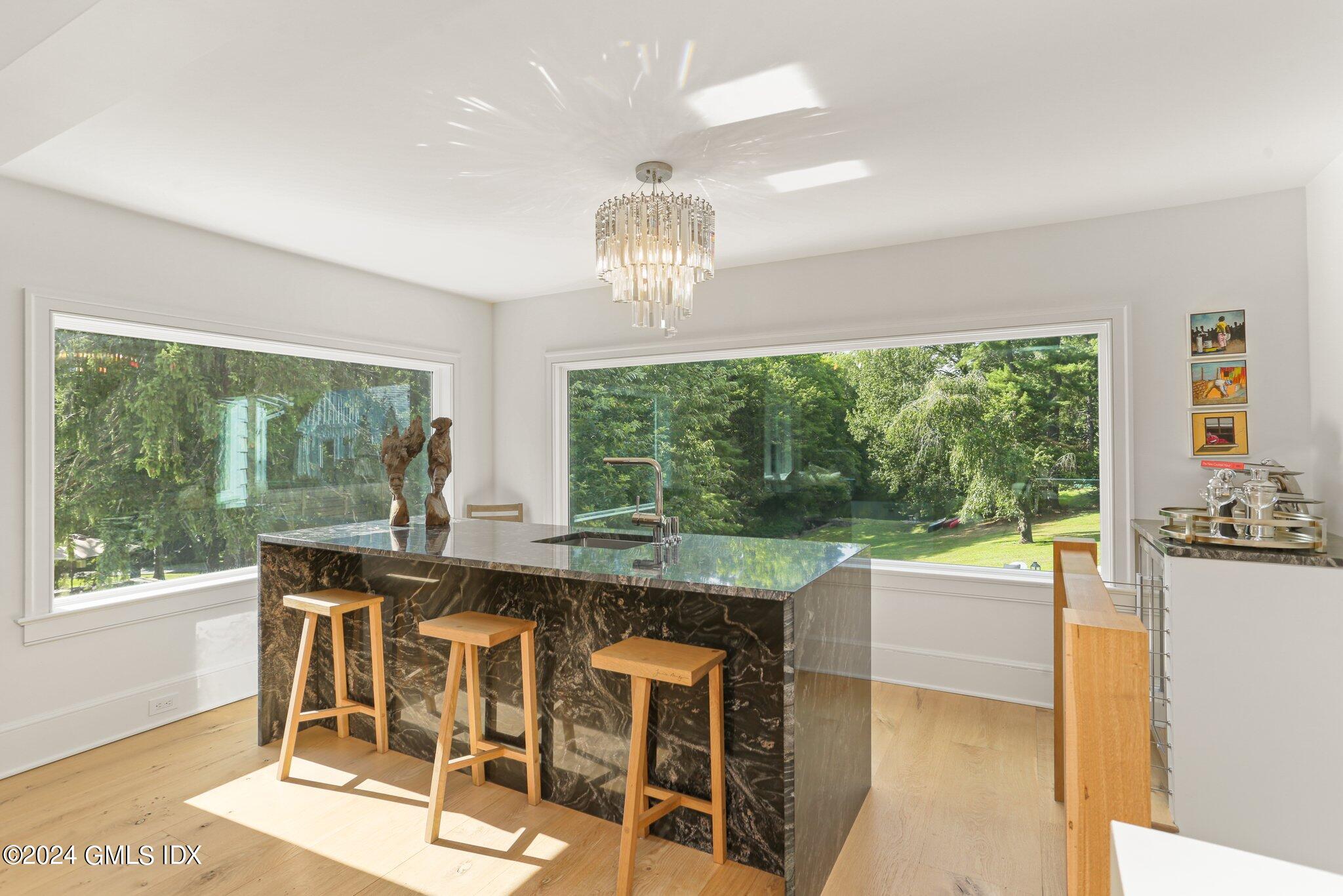 127 Dingletown Road Greenwich, CT 06830 - Photo 10 of 54 a dining room with wooden floor a chandelier a wooden table and chairs