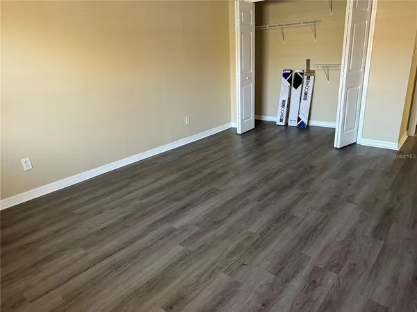 a view of a hallway with wooden floor and a closet