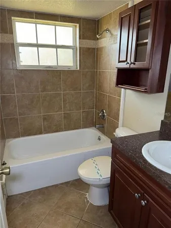 a bathroom with a granite countertop bathtub sink mirror vanity and toilet