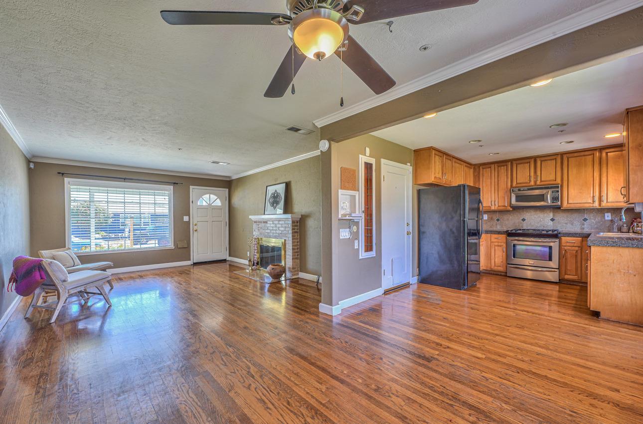 7 Grove Street Salinas, CA 93901 - Photo 9 of 33 a open kitchen with stainless steel appliances granite countertop a refrigerator a stove oven a dining table and chairs with wooden floor
