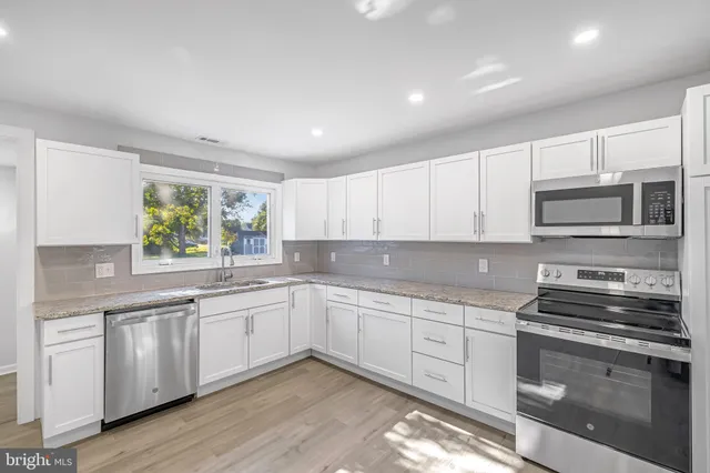 a kitchen with sink a microwave and cabinets