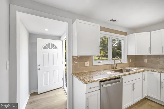 a kitchen with granite countertop cabinets sink and window