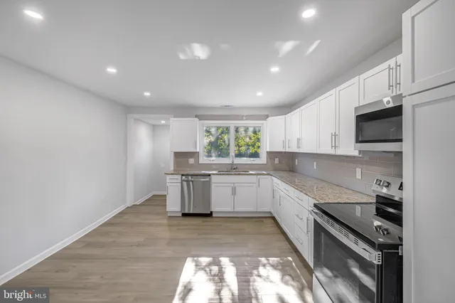 a kitchen with a sink stainless steel appliances and cabinets