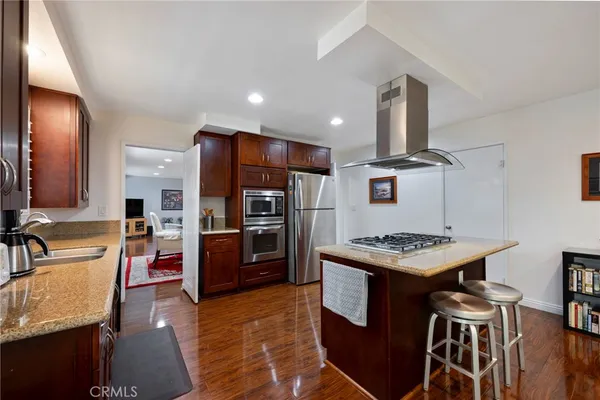 a kitchen with stainless steel appliances granite countertop a refrigerator and a stove top oven