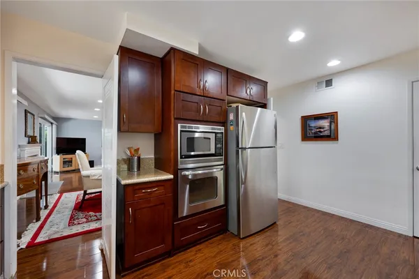 a kitchen with stainless steel appliances granite countertop a refrigerator a stove and a sink