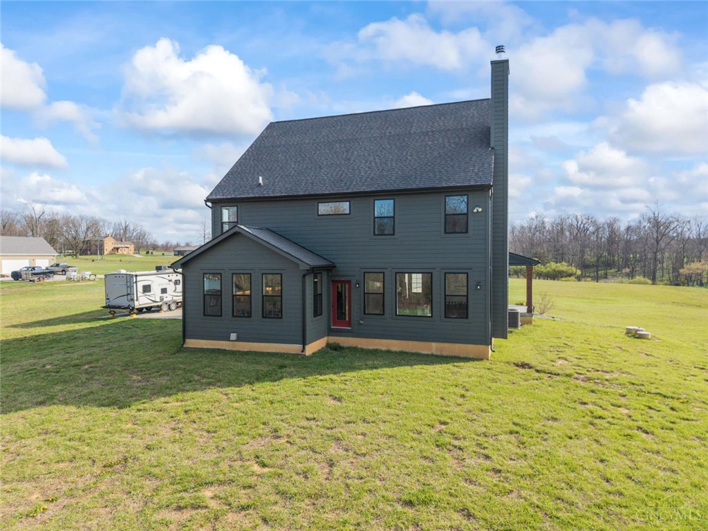 2425 Middleboro Road Clarksville, OH 45113 - Photo 6 of 91 The home features a dark exterior and a lush green lawn, offering ample outdoor space.