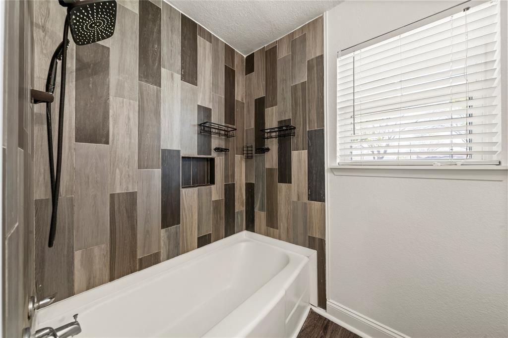 104 East Santa Anna Street Robinson, TX 76706 - Photo 32 of 36 a bathroom with a bathtub and a shower