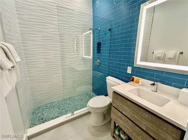 a bathroom with a sink a toilet and mirror