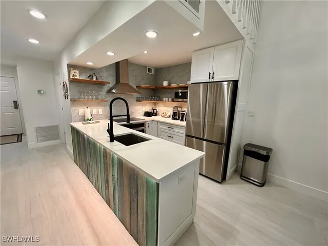 a kitchen with refrigerator a sink and cabinets