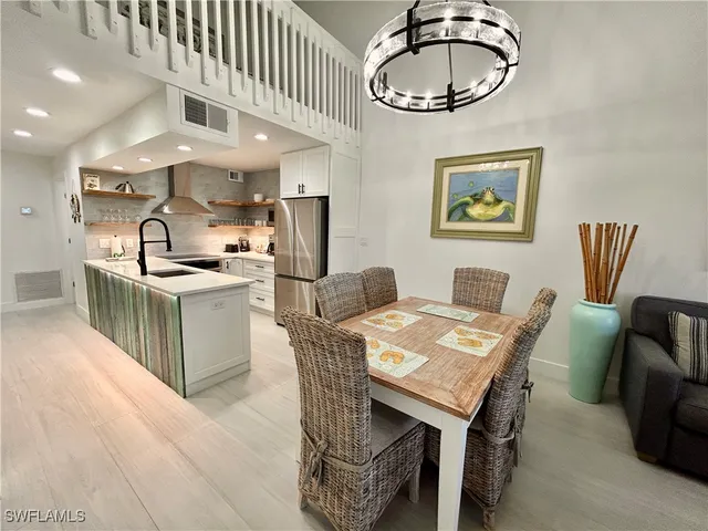 a kitchen with stainless steel appliances granite countertop a stove a kitchen island a dining table and chairs