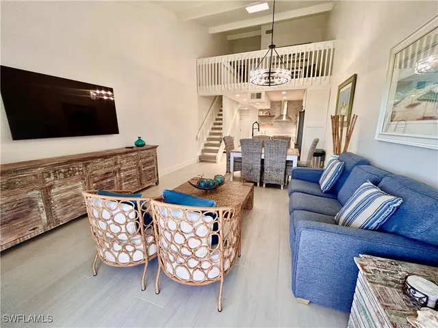 a living room with furniture a flat screen tv and a window