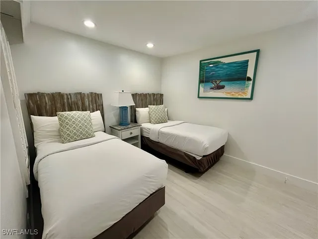 a bedroom with two beds and painting on the wall