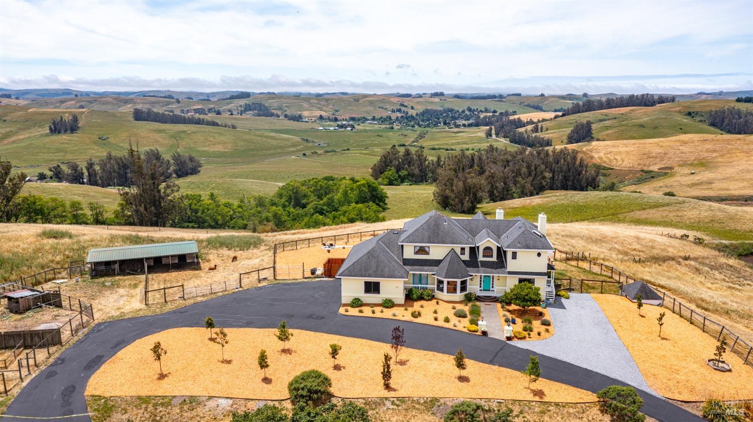 an aerial view of residential houses with outdoor space and ocean view