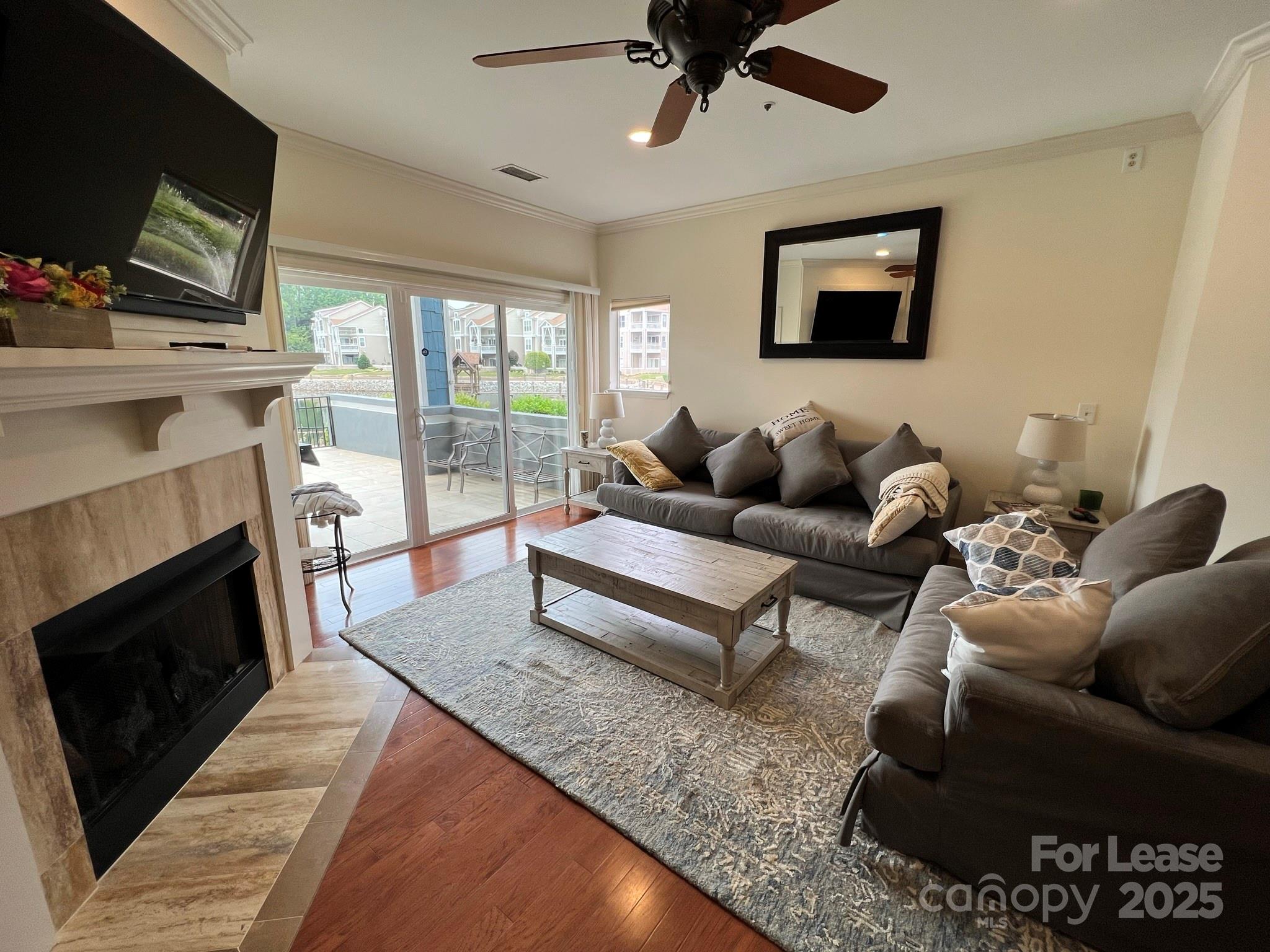 1140 Torrence Circle Davidson, NC 28036 - Photo 23 of 35 a living room with furniture a flat screen tv and a fireplace