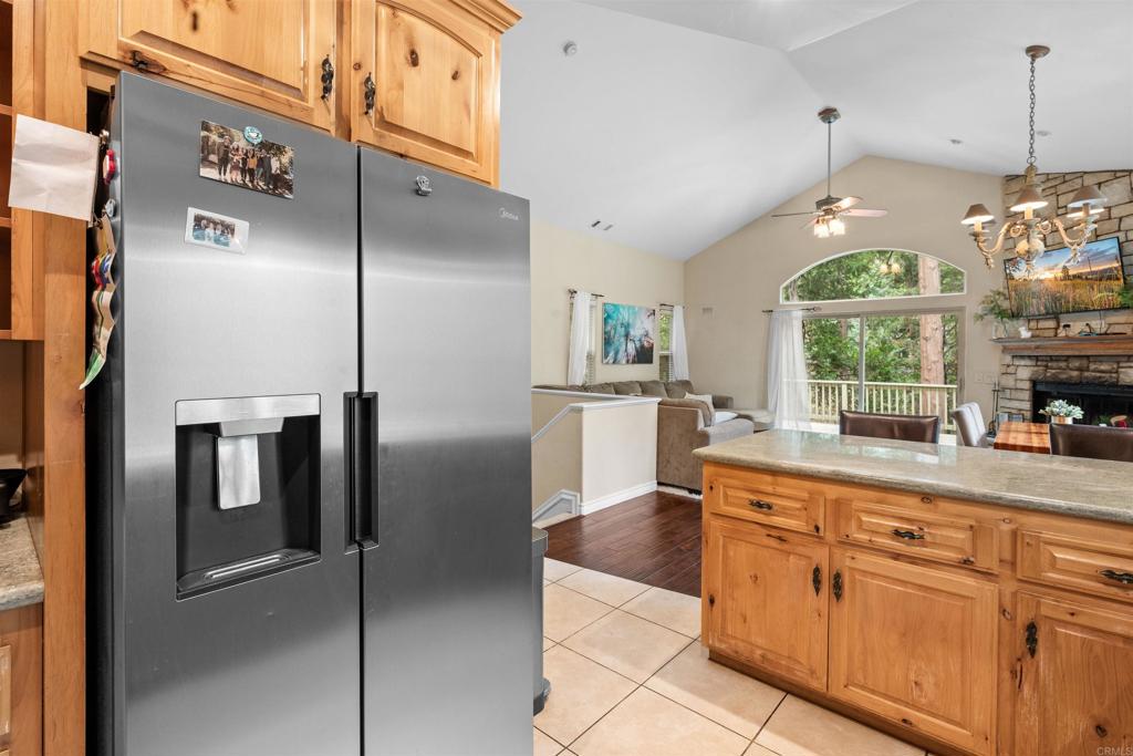26328 Jacqueline Road Twin Peaks, CA 92391 - Photo 12 of 37 a kitchen with stainless steel appliances granite countertop a refrigerator a sink dishwasher a oven a dining table and chairs with wooden floor