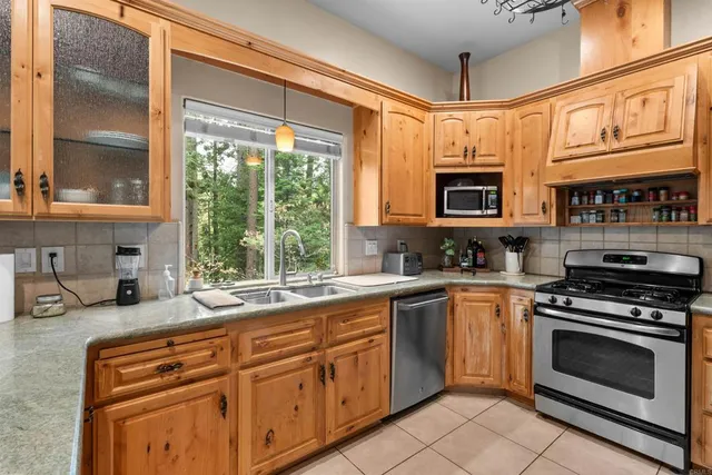 a kitchen with stainless steel appliances granite countertop a stove a sink and a microwave