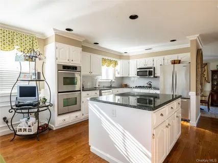 a kitchen with stainless steel appliances a stove refrigerator sink and microwave