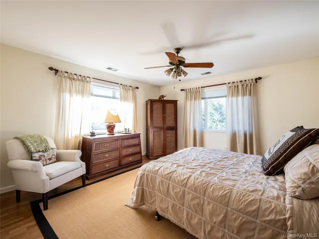 a spacious bedroom with a bed a couch and a dresser in it