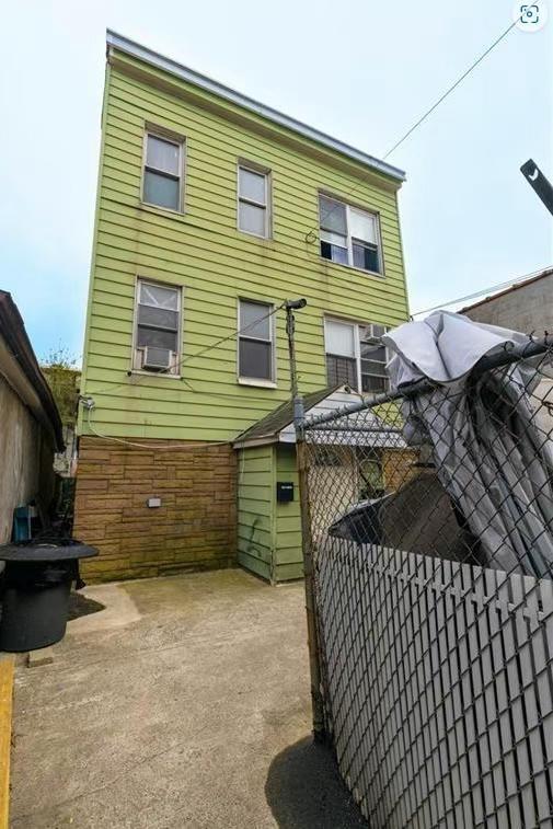 a view of a house with a yard and wooden fence