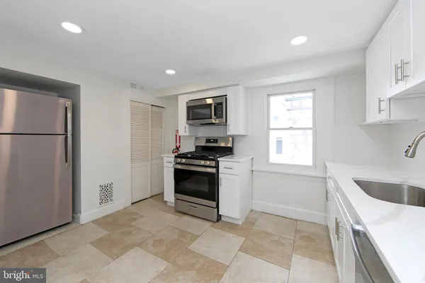 a kitchen with granite countertop a stove top oven sink and cabinets