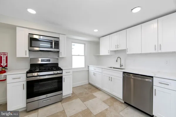 a kitchen with stainless steel appliances granite countertop a refrigerator and a stove top oven