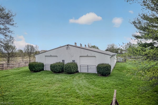 8675 West Smith Road Medina, OH 44256 - Photo 5 of 25 White metal outbuilding featuring two garage doors, two entry doors, and a partial fenced perimeter
