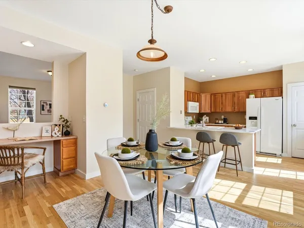 a kitchen with stainless steel appliances a stove a refrigerator and white cabinets with wooden floor
