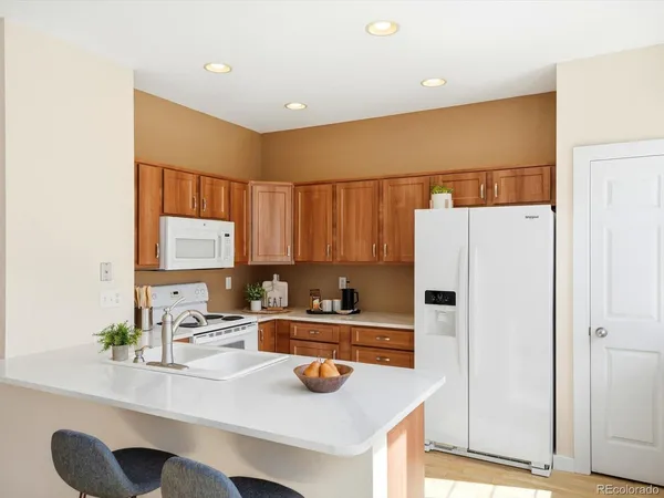 a kitchen that has a sink a stove and a refrigerator