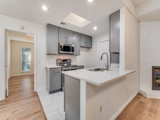 a kitchen with kitchen island a sink appliances and cabinets