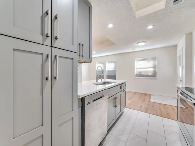 a kitchen with stainless steel appliances granite countertop a sink and a refrigerator