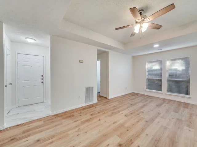 a view of an empty room with wooden floor