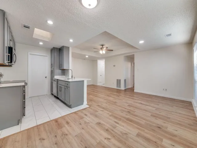 a large kitchen with stainless steel appliances a large counter top and a wooden floors
