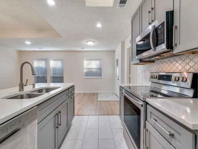 a kitchen with stainless steel appliances granite countertop a sink and a stove