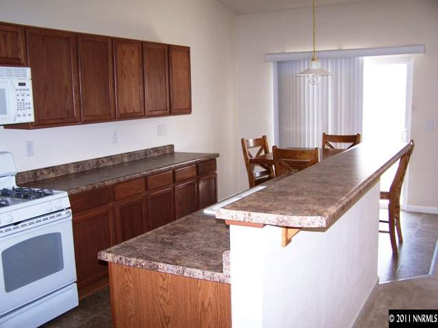 8946 Wynne Street Reno, NV 89506 - Photo 2 of 10 a kitchen with stainless steel appliances granite countertop stove top oven and cabinets