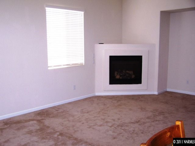 8946 Wynne Street Reno, NV 89506 - Photo 5 of 10 a view of an empty room with a fireplace and a window