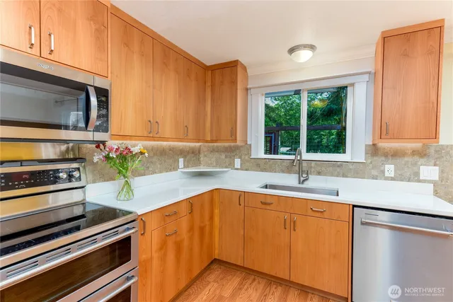 a kitchen with stainless steel appliances a sink dishwasher stove and microwave