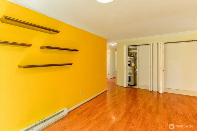 a view of a big room with wooden floor and a window