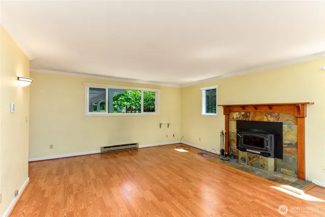 an empty room with windows and fireplace